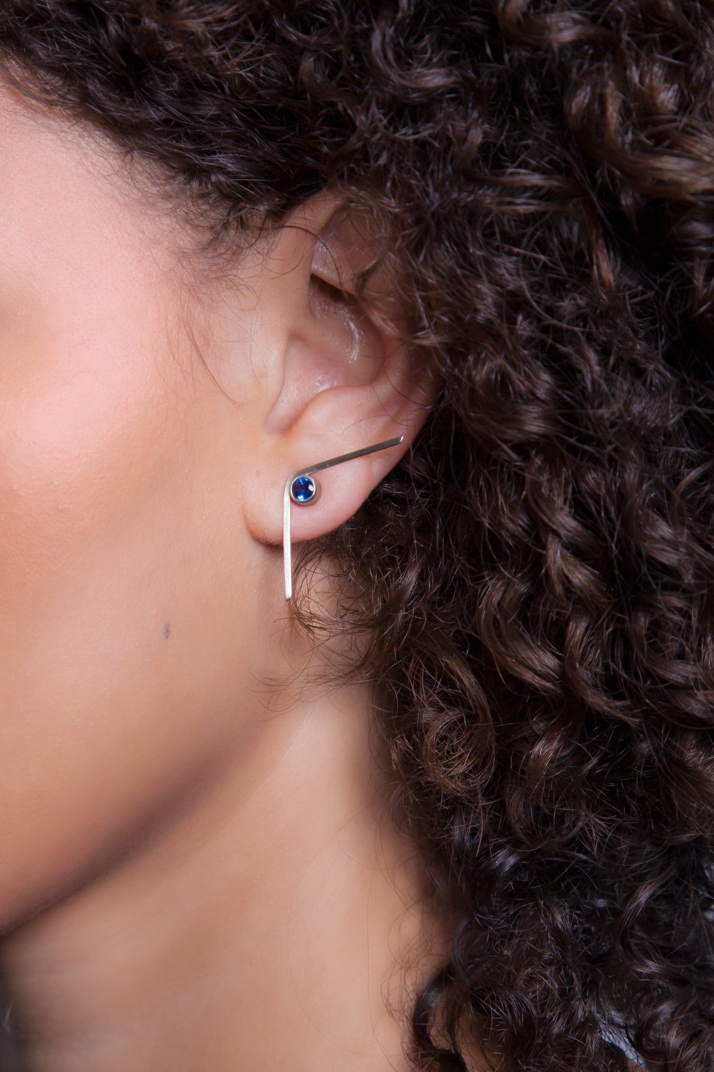 Boomerang earrings with bezel set blue sapphires in 14k white gold. Style: Button Stones: 5mm x 5mm Blue Sapphires Metal: 14k white gold Handmade by Meg C