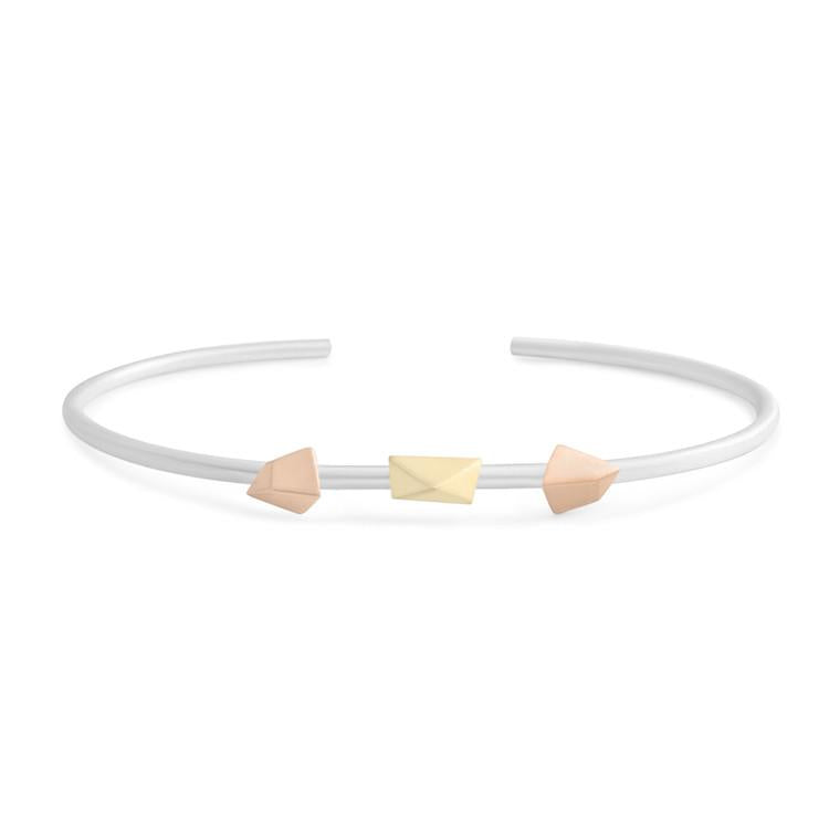 Two asymmetrical, five-sided "triangles" surround an asymmetrical "pyramid" on a delicate bracelet that wraps around the wrist. Size: 0.5cm x 5.5 cm diameter, 7g. Metal: Matte Sterling Silver Band; 18k Yellow & Rose Gold Made in New York City from ethically sourced materials. By Dana Bronfman