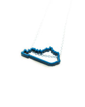 Show your Kentucky state pride with this blue, powder-coated Kentucky outline necklace! Great paired with Meg C's Blue Kentucky State Pin.  Size: 1" wide Metal: Blue powder coated brass; 18" Sterling Silver chain Handmade by Meg C