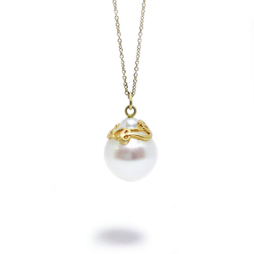 A South Sea pearl adorned with a hand-carved 18k yellow gold ribbon, with adjustable 18k yellow gold cable chain.   Size: 20mm wide; 16