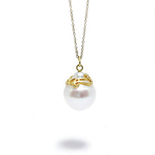 A South Sea pearl adorned with a hand-carved 18k yellow gold ribbon, with adjustable 18k yellow gold cable chain.   Size: 20mm wide; 16"-18" chain Stone: South Sea Pearl  Metal: 18k Yellow Gold Handmade by Meg C