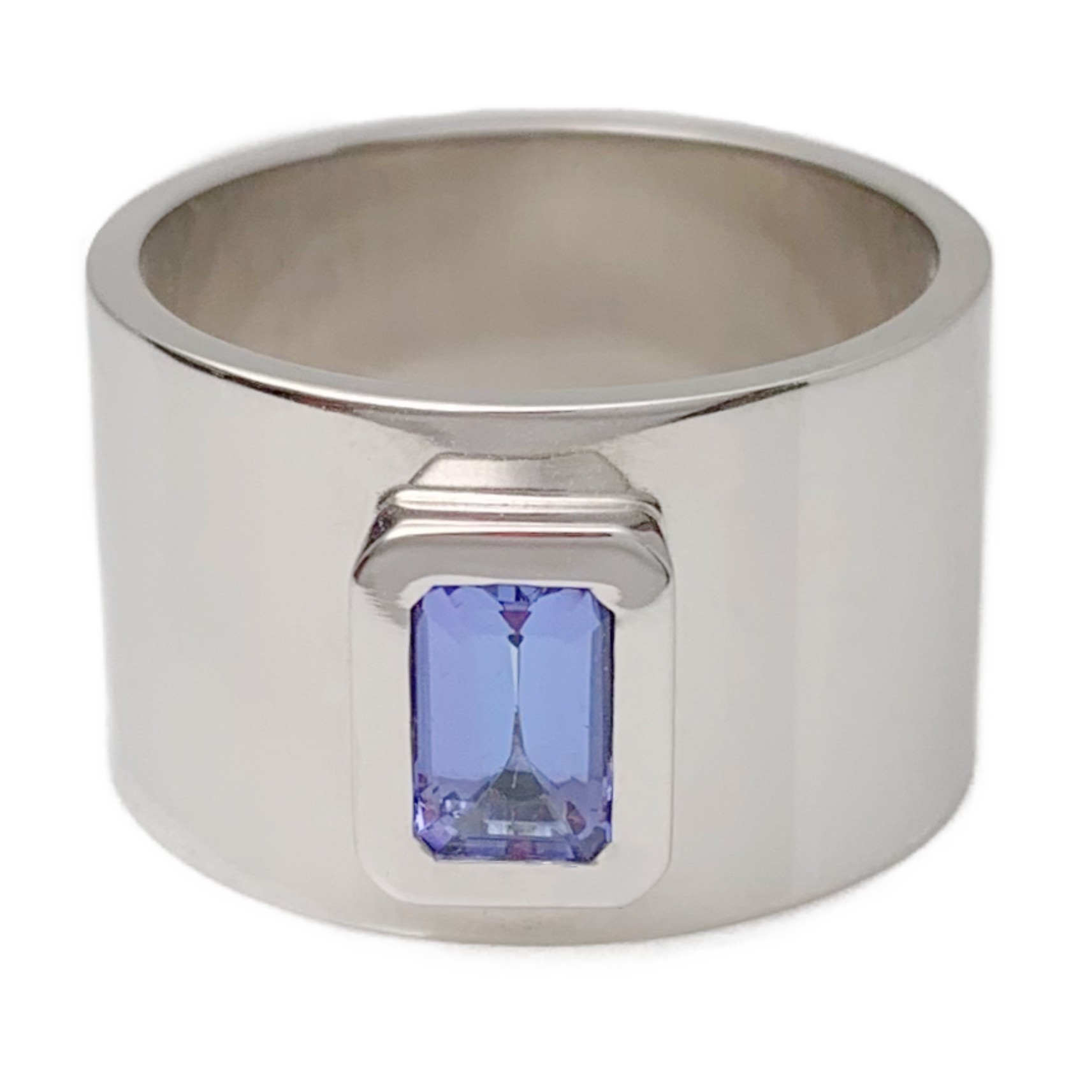 Featuring a bright, beautiful, emerald cut Tanzanite, bezel set in a wide white gold band.  Size: 6 Dimensions: 12mm wide band Stone: .056ct emerald cut Tanzanite Metal: 14k White Gold Handmade by Meg C